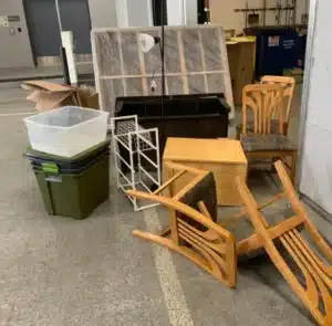 Old chairs, shelves, and household furniture stacked for junk removal in Alexandria VA
