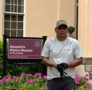 Junk Removal Service Near Alexandria VA Location Sign – MA Junk Removal Team member standing next to Alexandria VA location sign for junk removal service