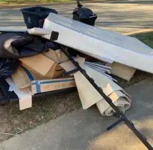 Household junk including mattress, boxes, and carpet set out for removal in Alexandria VA