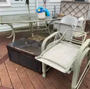 Worn outdoor chairs, table, and storage chest set for junk removal in Arlington VA