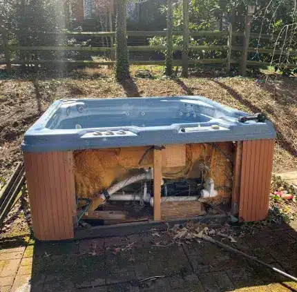 Old broken hot tub ready for removal in Alexandria backyard