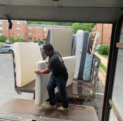 Mattress Removal in Arlington – MA Junk Removal & Cleaning Services Worker loading multiple old mattresses for removal in Arlington VA apartment area