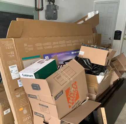 Garage filled with moving boxes, electronics packaging, and clutter for junk removal in Virginia