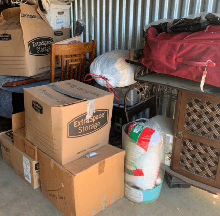 Packed storage unit with boxes, furniture, and household junk in McLean