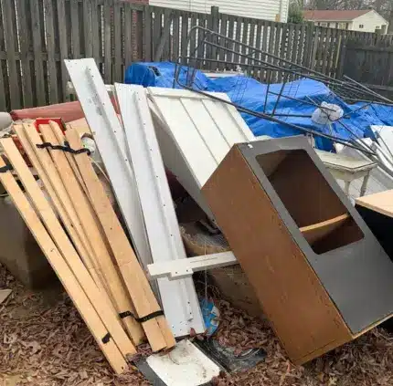 wood planks, furniture pieces, and outdoor debris piled for yard junk removal in Arlington VA